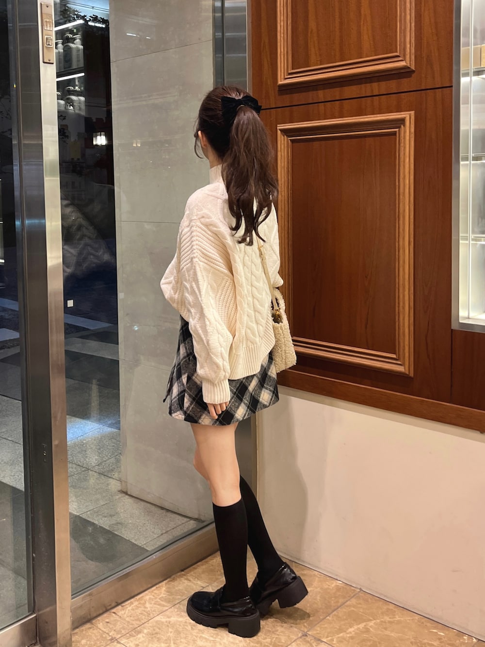 ホワイト系のニット/セーター、その他のスカート、ブラック系のローファーを着用したレディースの秋コーディネートの2枚目の写真