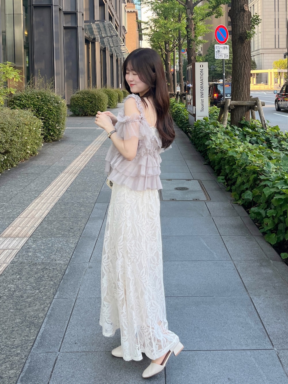 ホワイト系のバッグ、ピンク系のトップス、ホワイト系のスカートを着用したレディースの夏コーディネートの2枚目の写真