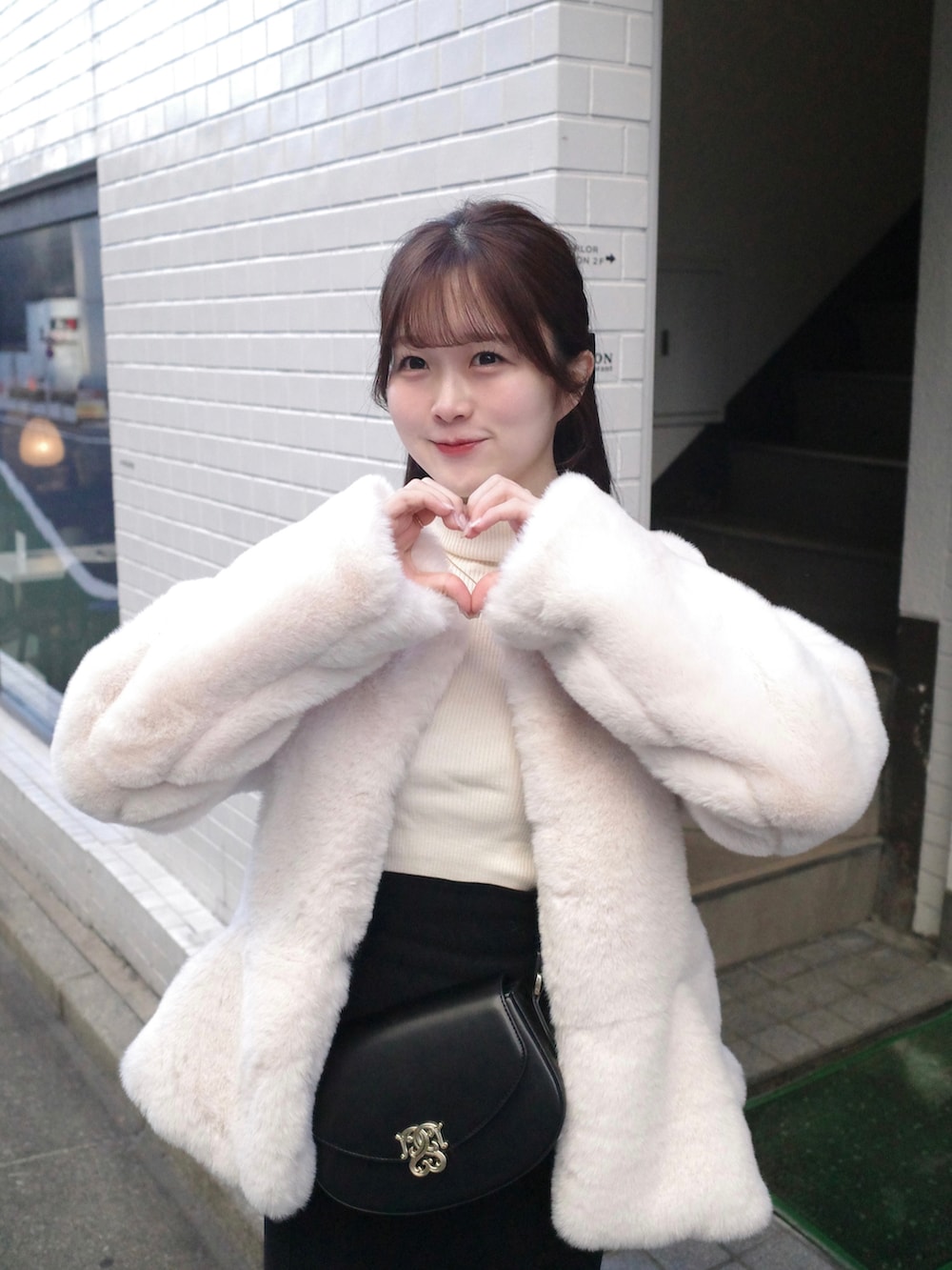 ホワイト系のノーカラーコート、ブラック系のショルダーバッグ、ホワイト系のニット/セーターを着用したレディースの秋コーディネートの3枚目の写真