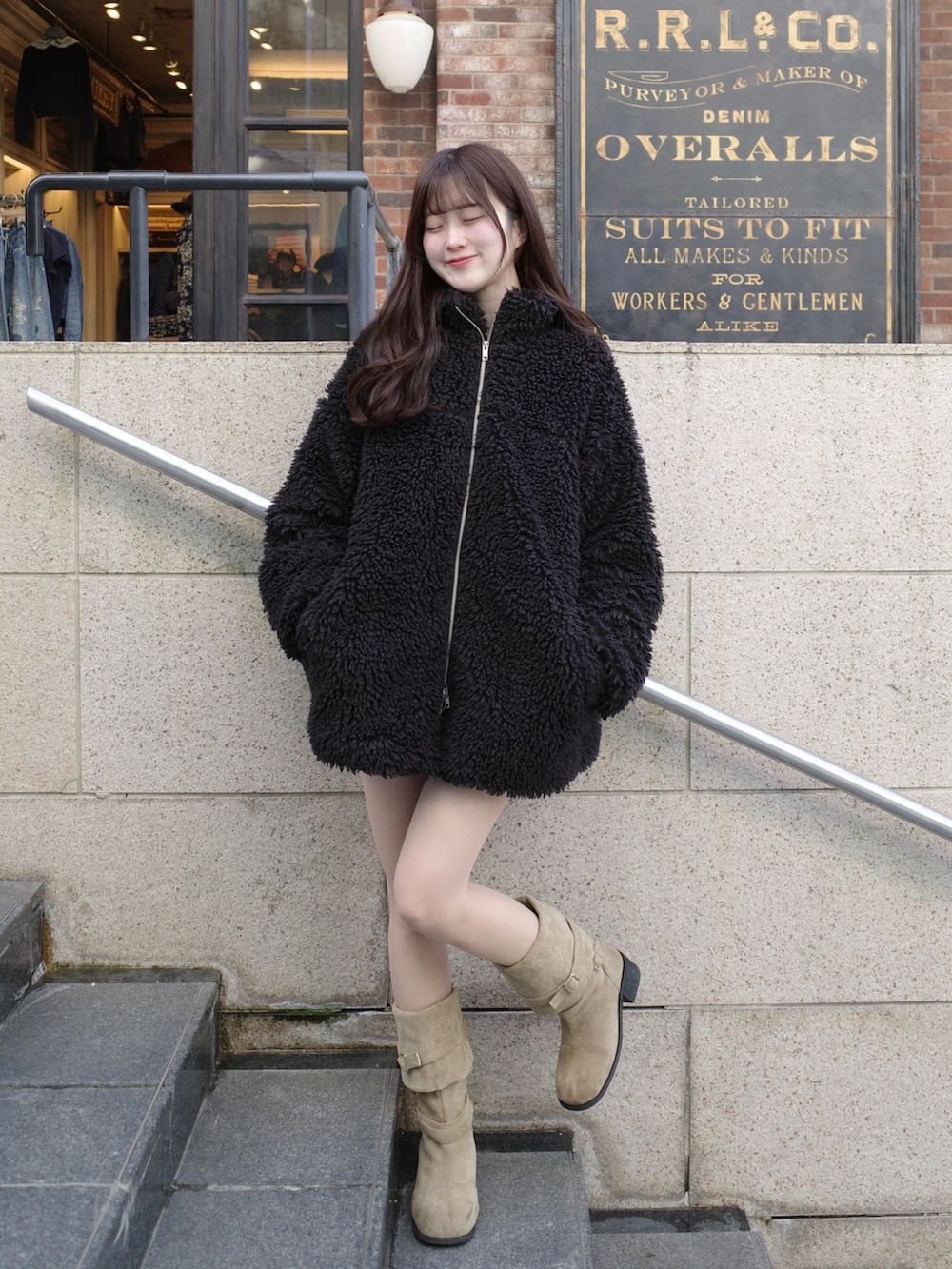 ブラック系のブルゾン、ベージュ系のブーツを着用したレディースの冬コーディネートの2枚目の写真