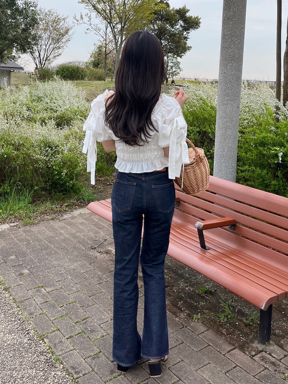 ホワイト系のシャツ/ブラウス、ブルー系のデニムパンツ、ベージュ系のかごバッグを着用したレディースの春コーディネートの2枚目の写真