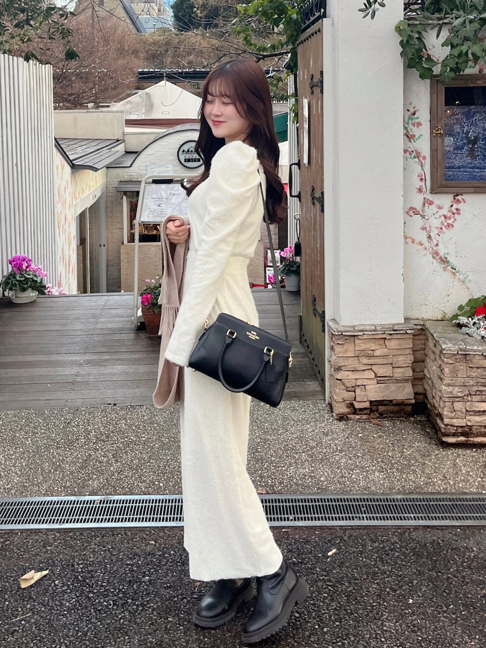 ホワイト系のトップス、ホワイト系のスカート、ベージュ系のマフラーを着用したレディースの冬コーディネートの2枚目の写真