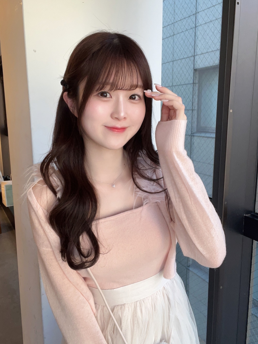 ピンク系のアンサンブル、ホワイト系のショルダーバッグ、ホワイト系のスカートを着用したレディースの冬コーディネートの2枚目の写真