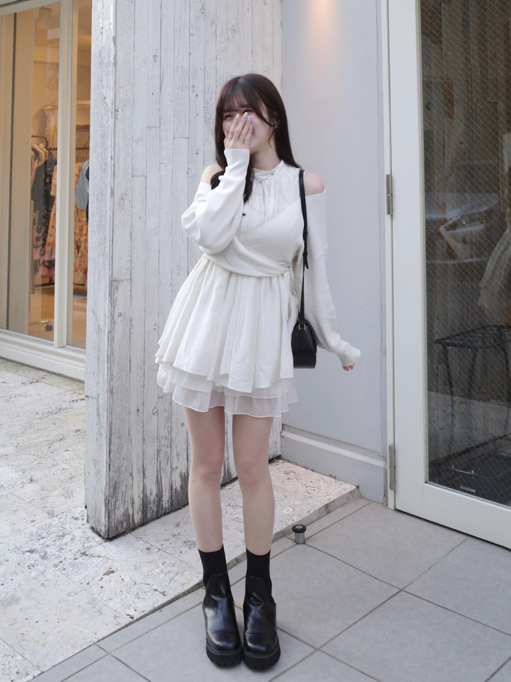 ホワイト系のニット/セーター、ホワイト系のスカートを着用したレディースの春コーディネートの2枚目の写真