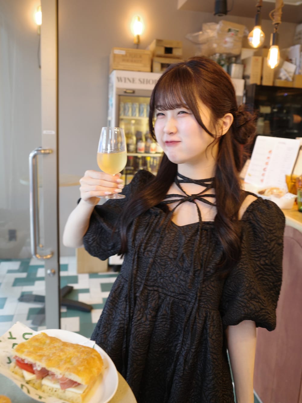 ブラック系のワンピース、ホワイト系のバッグを着用したレディースの春コーディネートの3枚目の写真