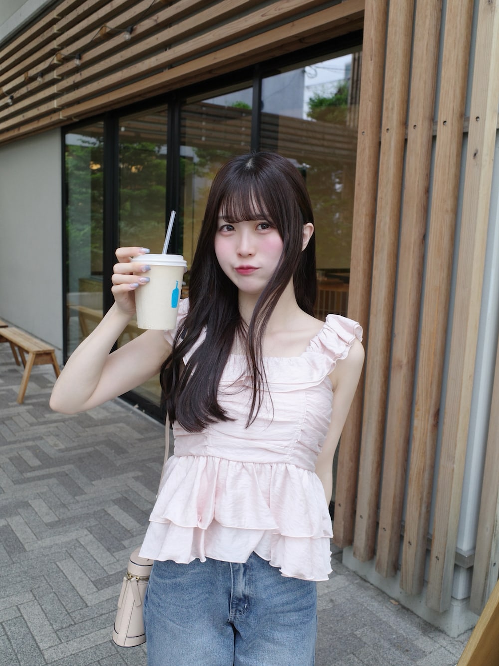 ホワイト系のサンダル、ピンク系のトップス、ブルー系のデニムパンツを着用したレディースの夏コーディネートの3枚目の写真