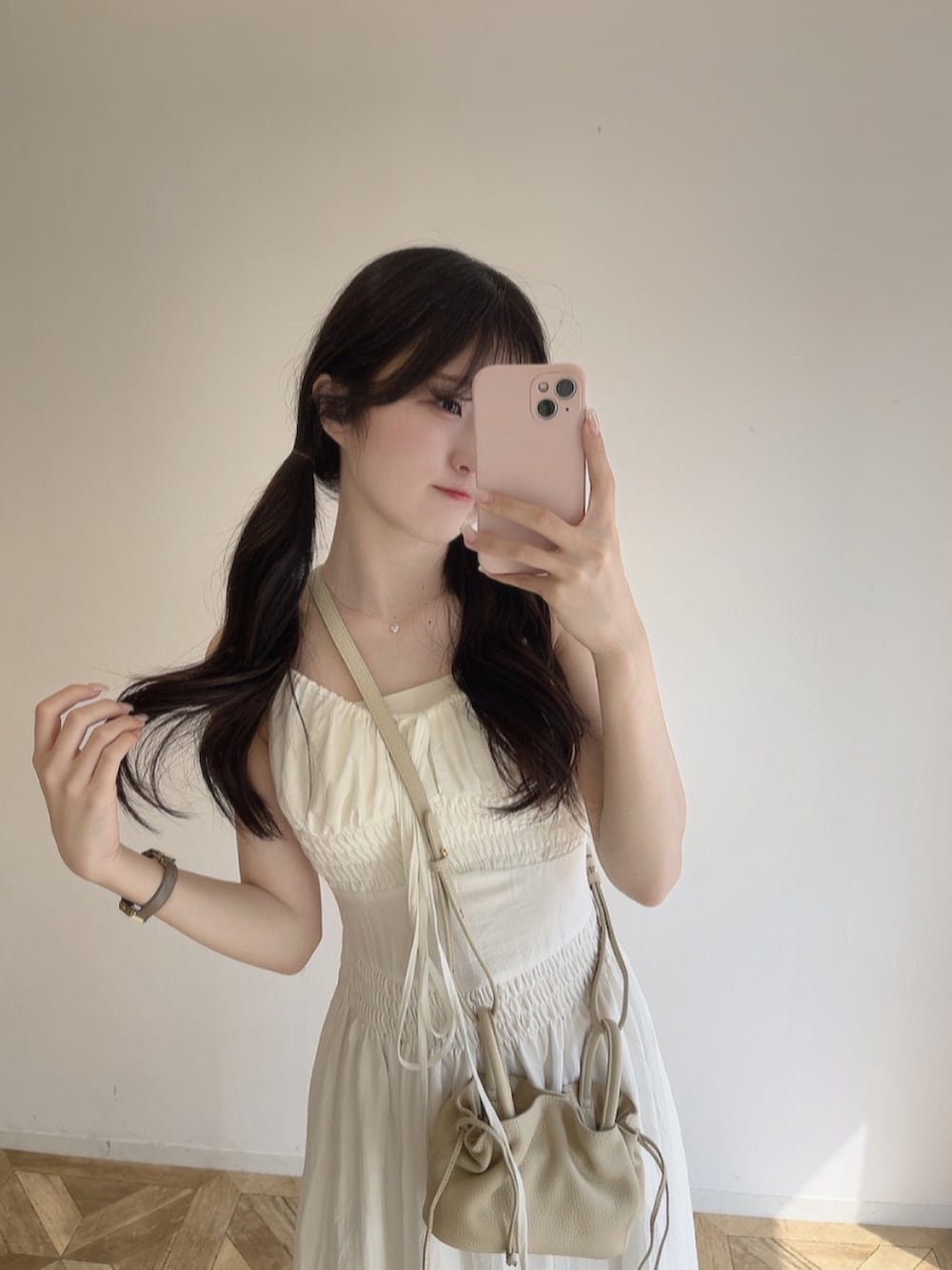 ホワイト系のワンピース/ドレス、ベージュ系のショルダーバッグ、ホワイト系のサンダルを着用したレディースの春コーディネートの2枚目の写真