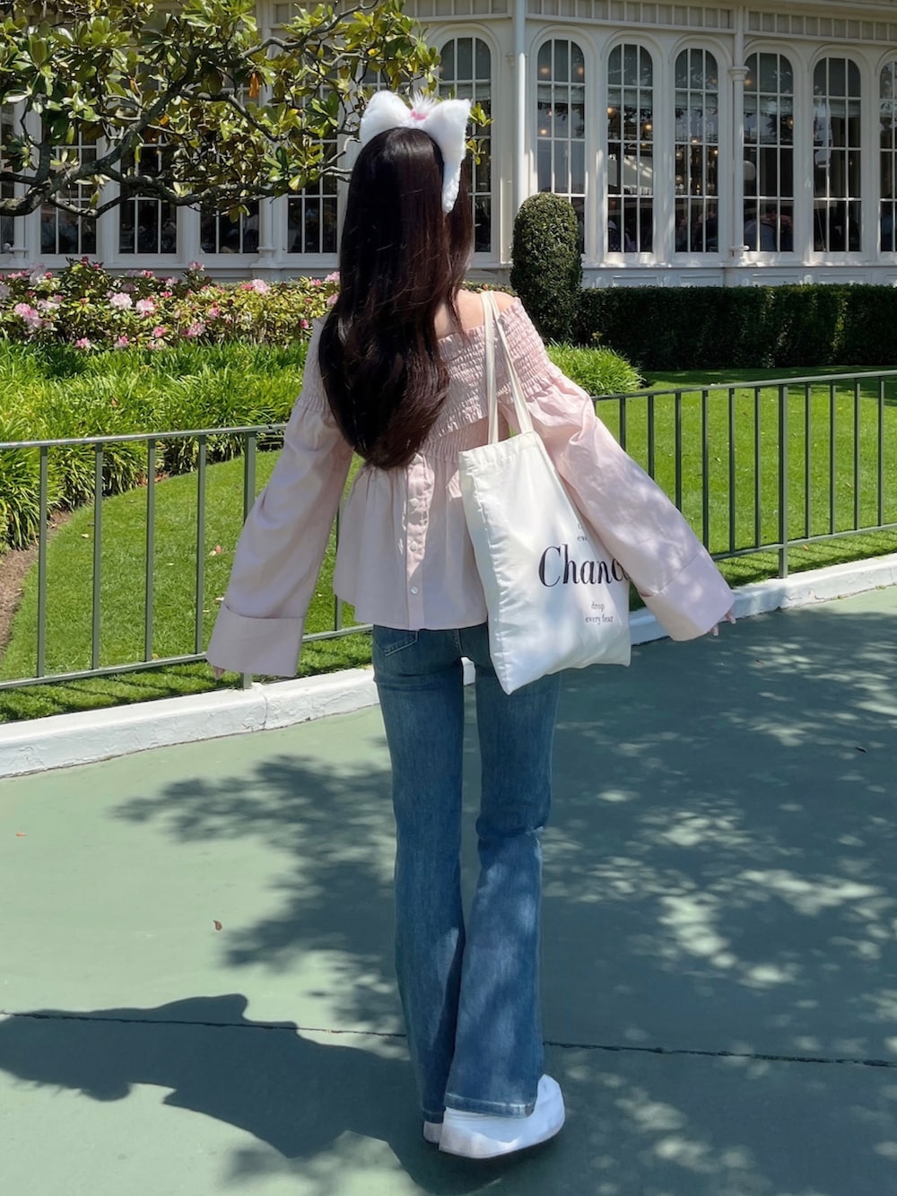 ピンク系のシャツ/ブラウス、ブルー系のデニムパンツ、ホワイト系のスニーカーを着用したレディースの夏コーディネートの2枚目の写真