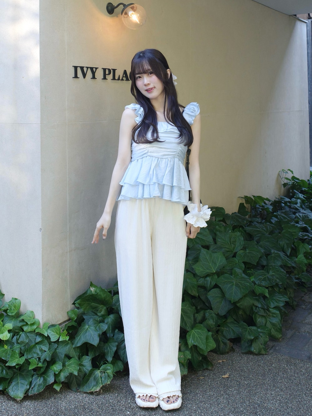 ブルー系のシャツ/ブラウス、ホワイト系のパンツ、ホワイト系のシューズを着用したレディースの夏コーディネートの2枚目の写真