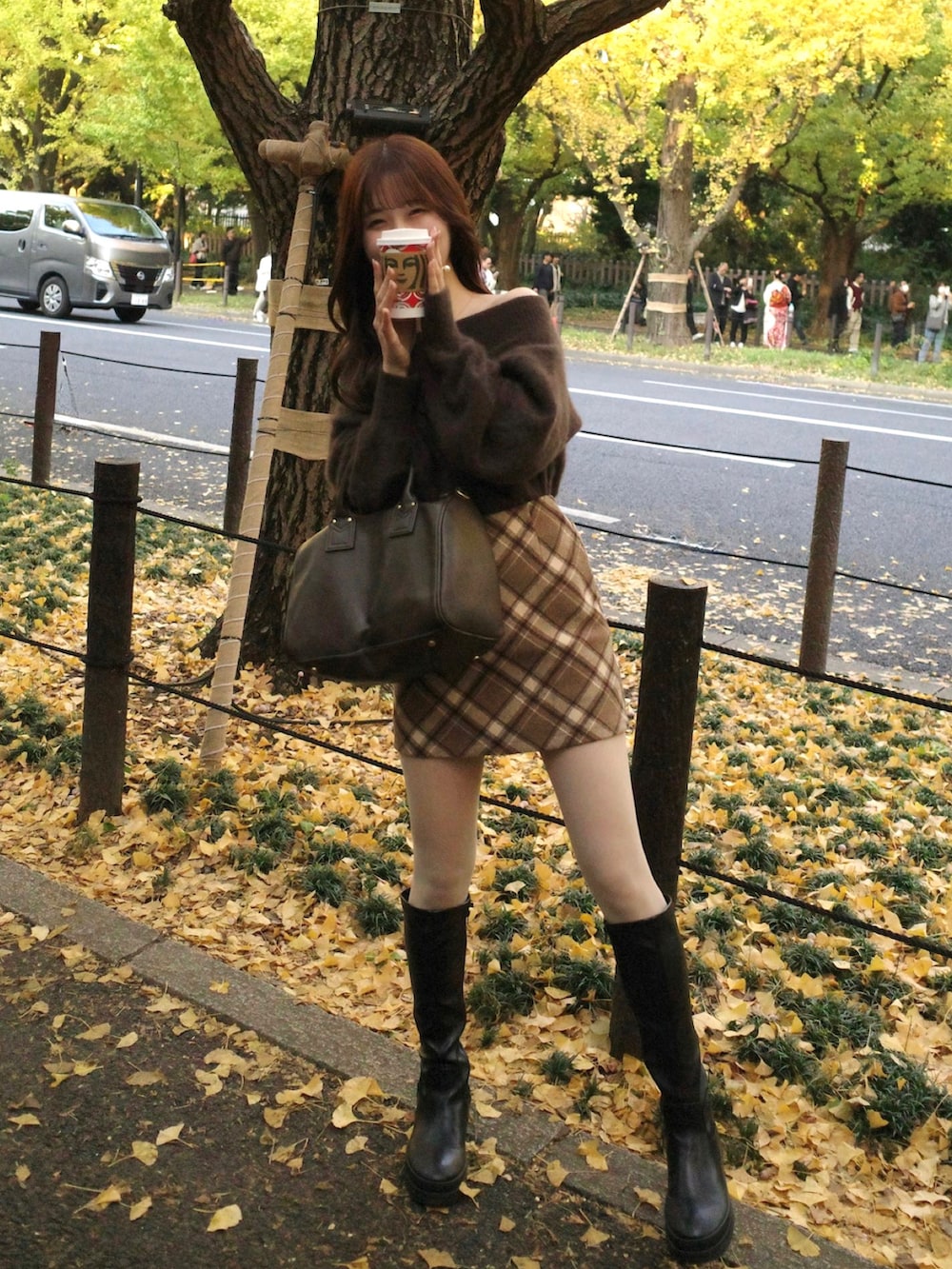 ブラウン系のニット/セーター、その他のスカート、ブラック系のブーツを着用したレディースの秋コーディネートの2枚目の写真