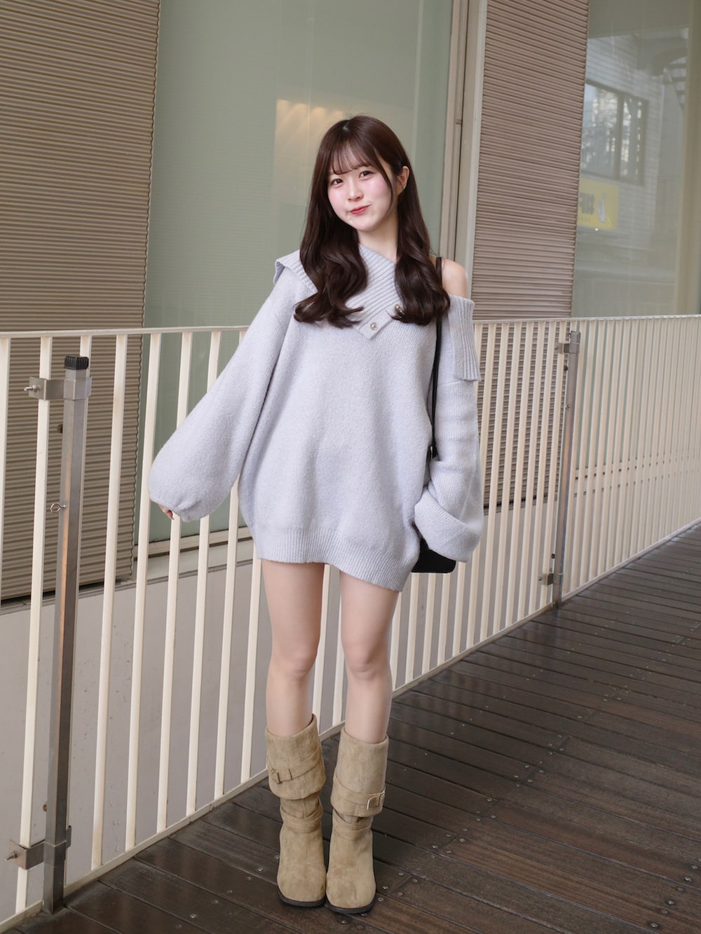 ブルー系のワンピース、ブラック系のボストンバッグ、ベージュ系のブーツを着用したレディースの冬コーディネートの3枚目の写真