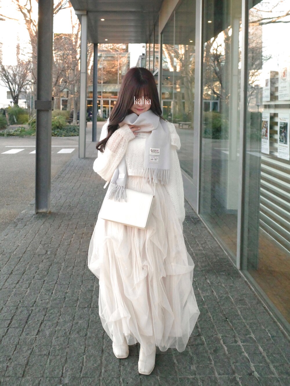 ホワイト系のニット/セーター、ホワイト系のスカート、ホワイト系のショルダーバッグを着用したレディースの冬コーディネートの3枚目の写真