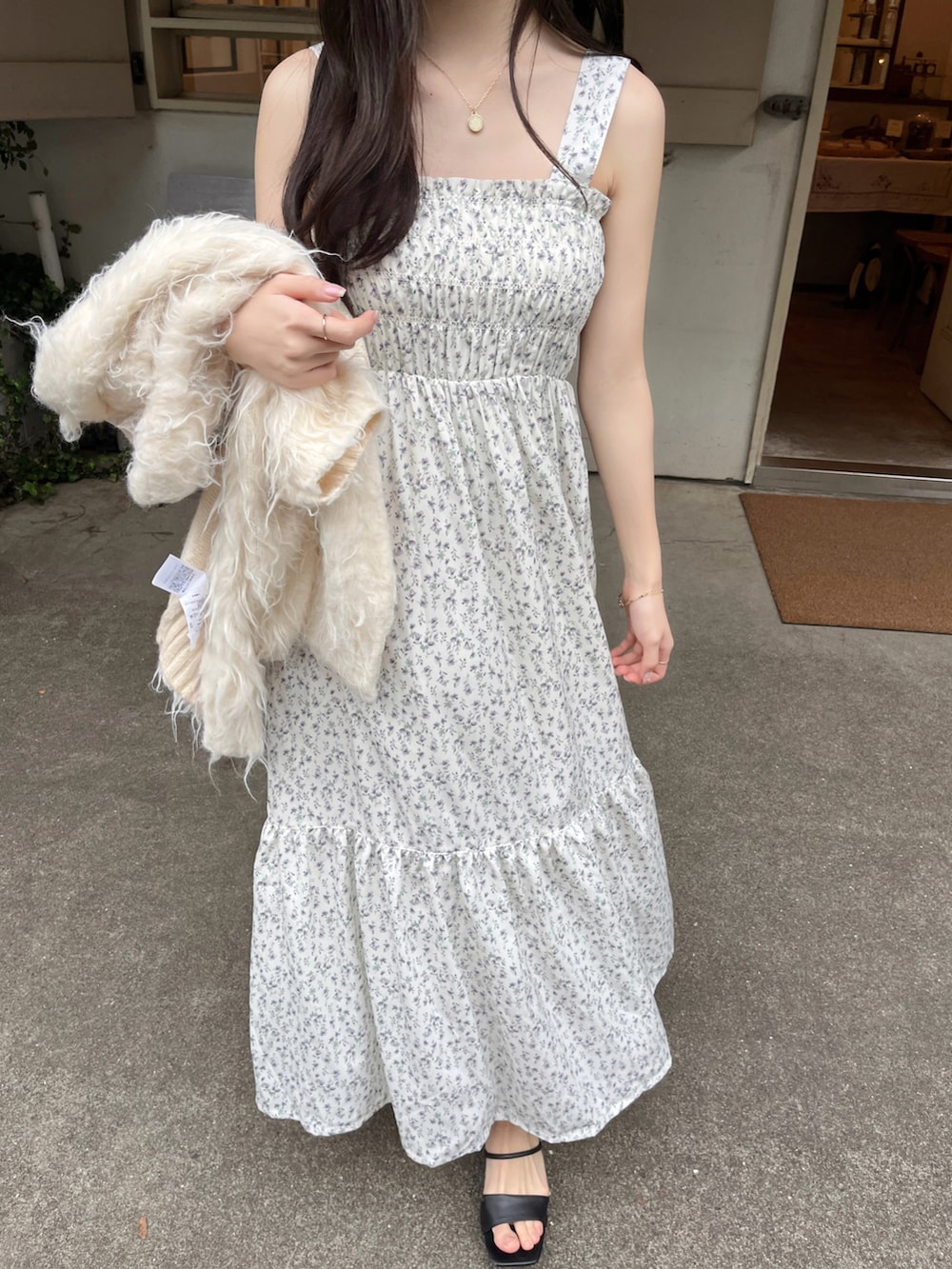 ホワイト系のワンピース/ドレス、ホワイト系のカーディガン/ボレロ、ブラック系のサンダルを着用したレディースの春コーディネートの2枚目の写真