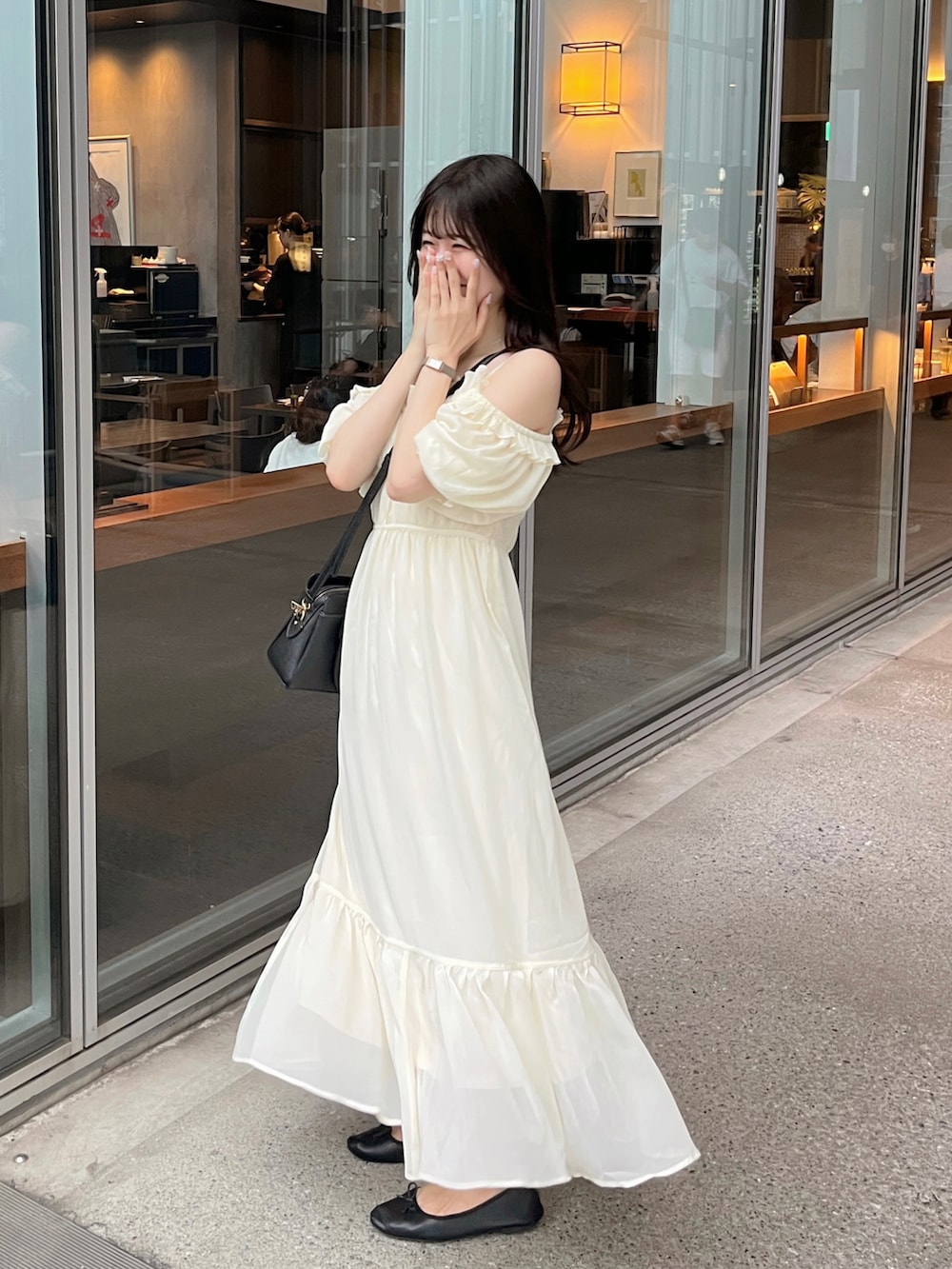 ブラック系のバッグ、ベージュ系のワンピースを着用したレディースの夏コーディネートの2枚目の写真