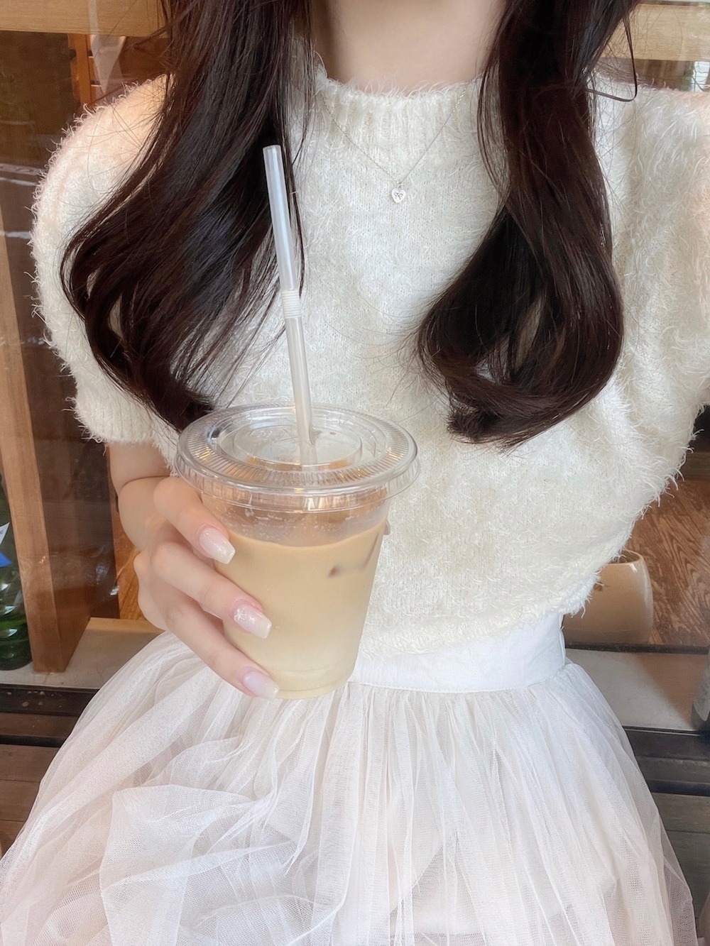 ホワイト系のスカート、ピンク系のバッグ、ホワイト系のニット/セーターを着用したレディースの秋コーディネートの4枚目の写真