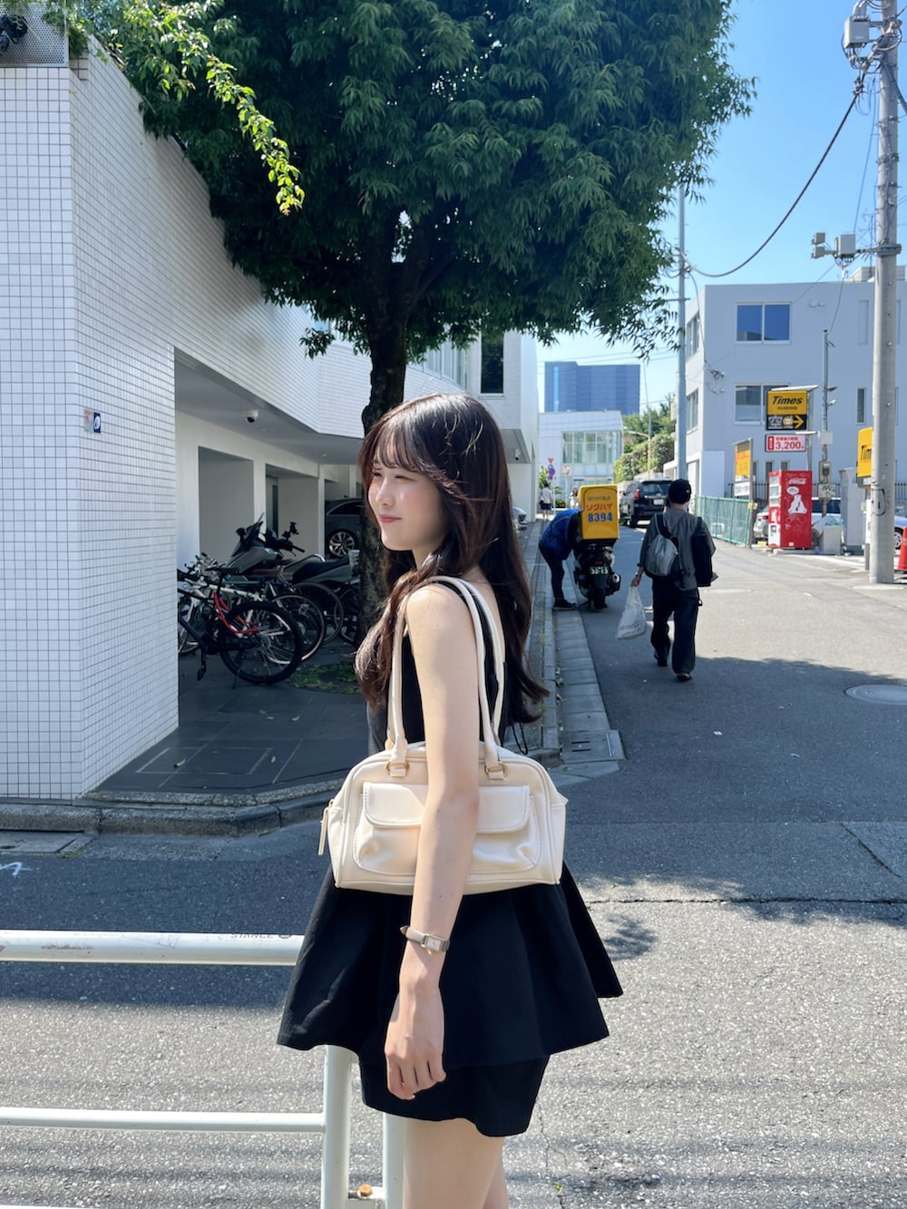 ブラック系のつなぎ/オールインワン、ホワイト系のシューズ、ホワイト系のハンドバッグを着用したレディースの夏コーディネートの2枚目の写真