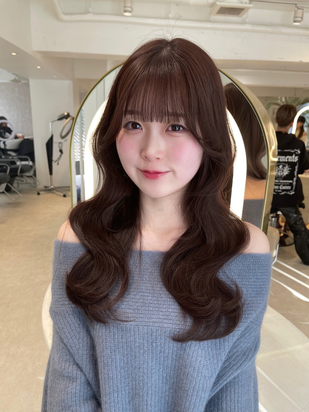 ブルー系のワンピース、ブラック系のブーツを着用したレディースの冬コーディネートの2枚目の写真