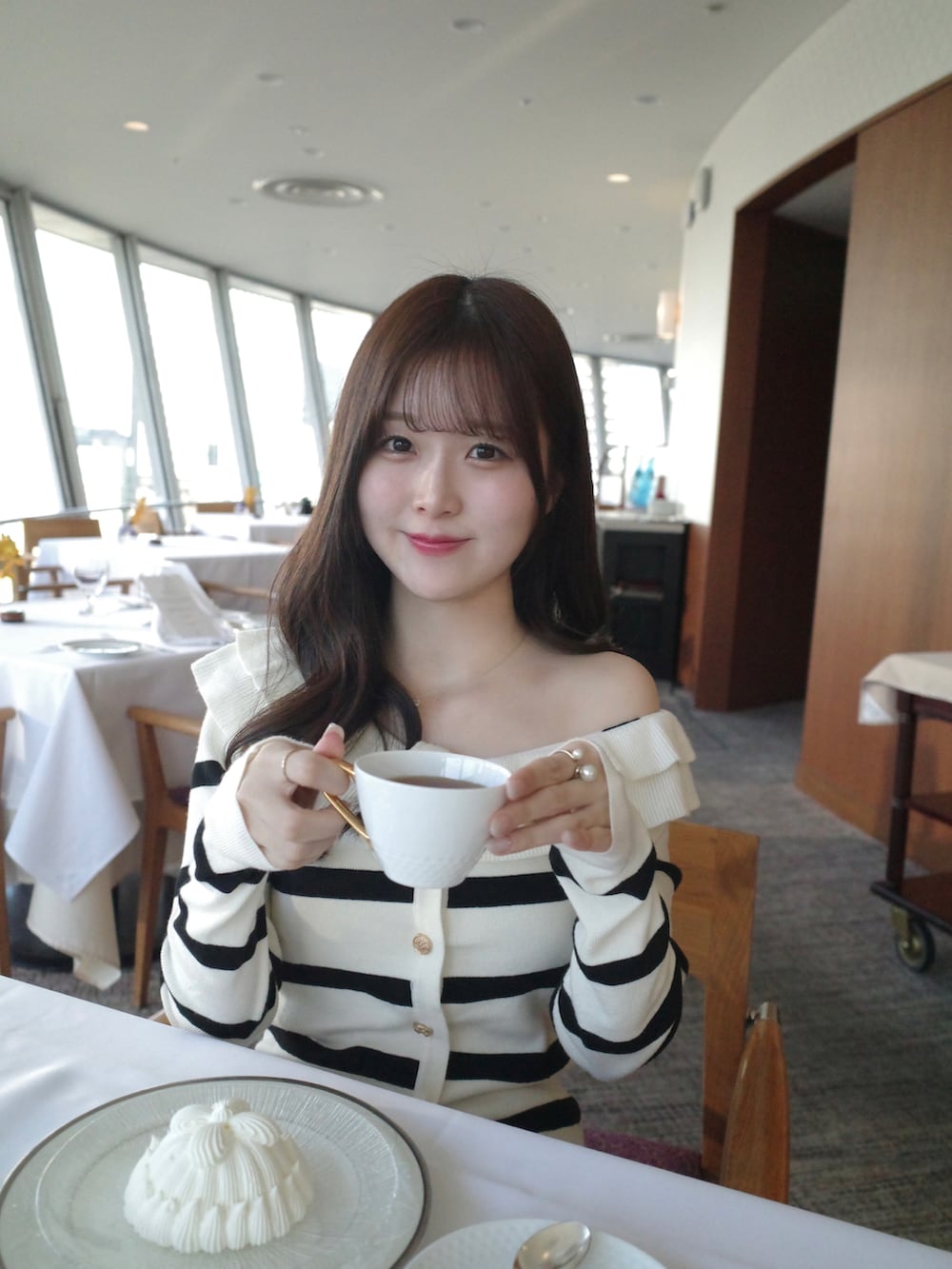 ホワイト系のトップス、ブラック系のスカート、ホワイト系のその他アウターを着用したレディースの冬コーディネートの3枚目の写真