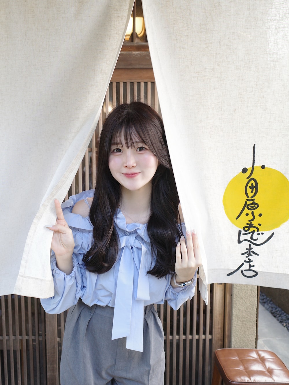 ブルー系のシャツ/ブラウス、グレー系のスラックスを着用したレディースの春コーディネートの2枚目の写真