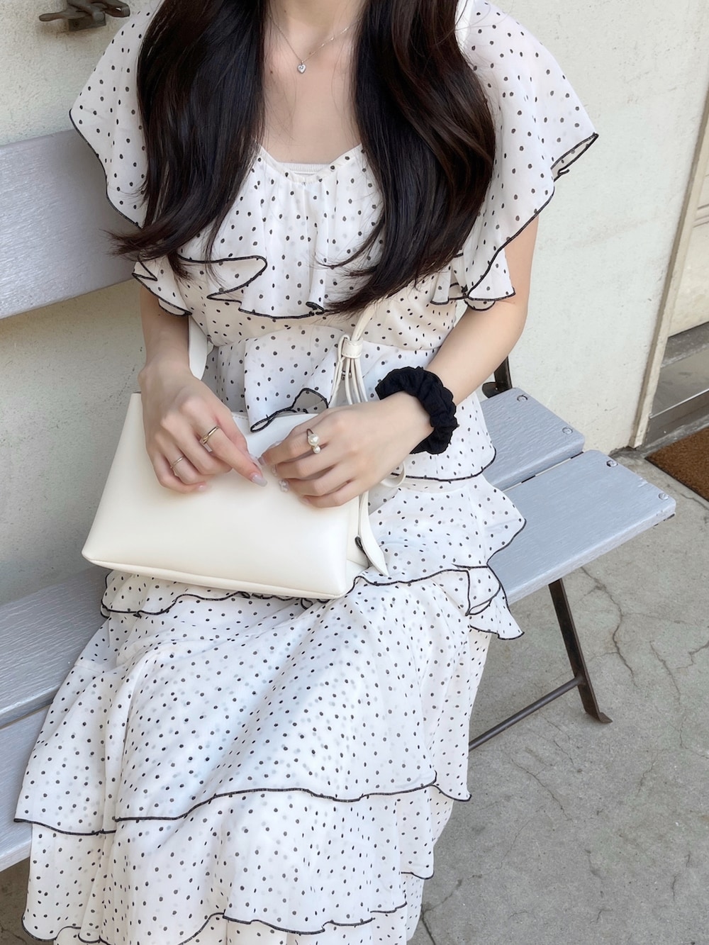 ベージュ系のショルダーバッグ、ホワイト系のワンピース/ドレスを着用したレディースの夏コーディネートの5枚目の写真