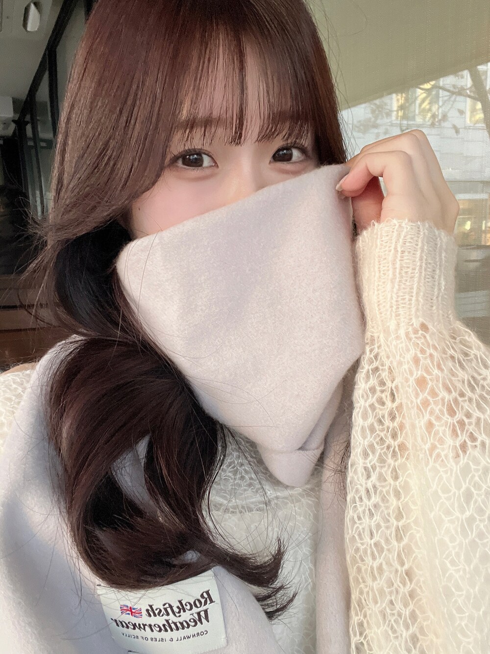 ホワイト系のニット/セーター、ホワイト系のスカート、ホワイト系のショルダーバッグを着用したレディースの冬コーディネートの2枚目の写真