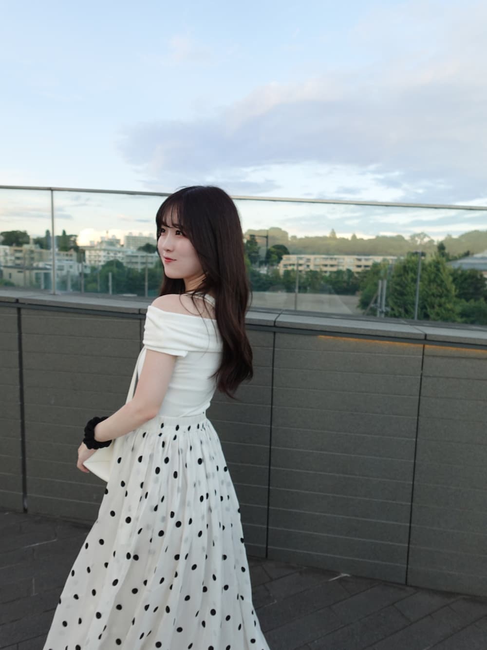 ホワイト系のスカート、ブラック系のショルダーバッグ、ホワイト系のトップスを着用したレディースの秋コーディネートの2枚目の写真