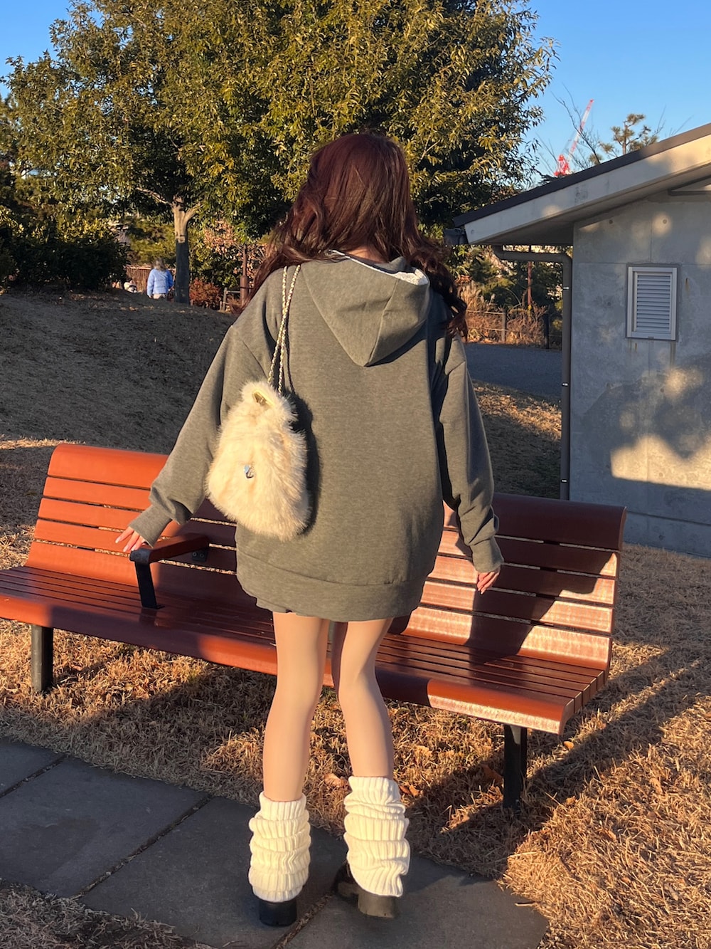 グレー系のセットアップ、ホワイト系のレッグウォーマーを着用したレディースの冬コーディネートの3枚目の写真