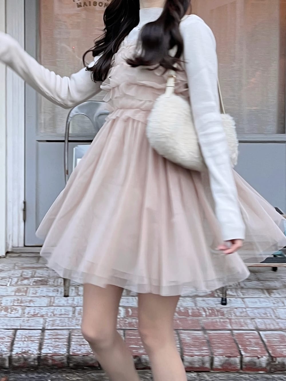 ピンク系のワンピース、ブラウン系のローファー、ベージュ系のハンドバッグを着用したレディースの冬コーディネートの3枚目の写真