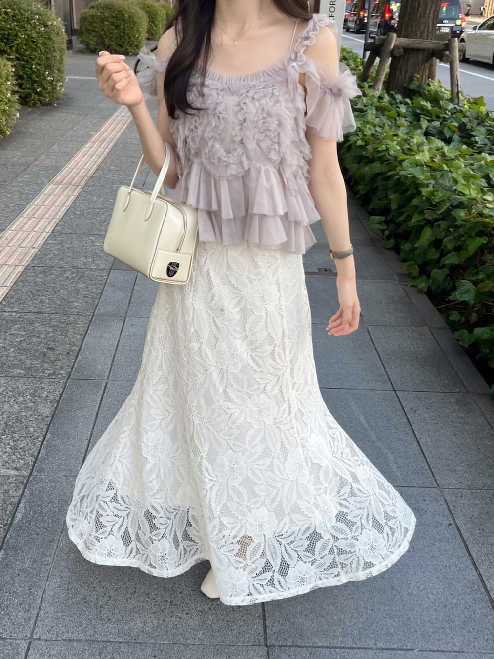 ホワイト系のバッグ、ピンク系のトップス、ホワイト系のスカートを着用したレディースの夏コーディネートの3枚目の写真