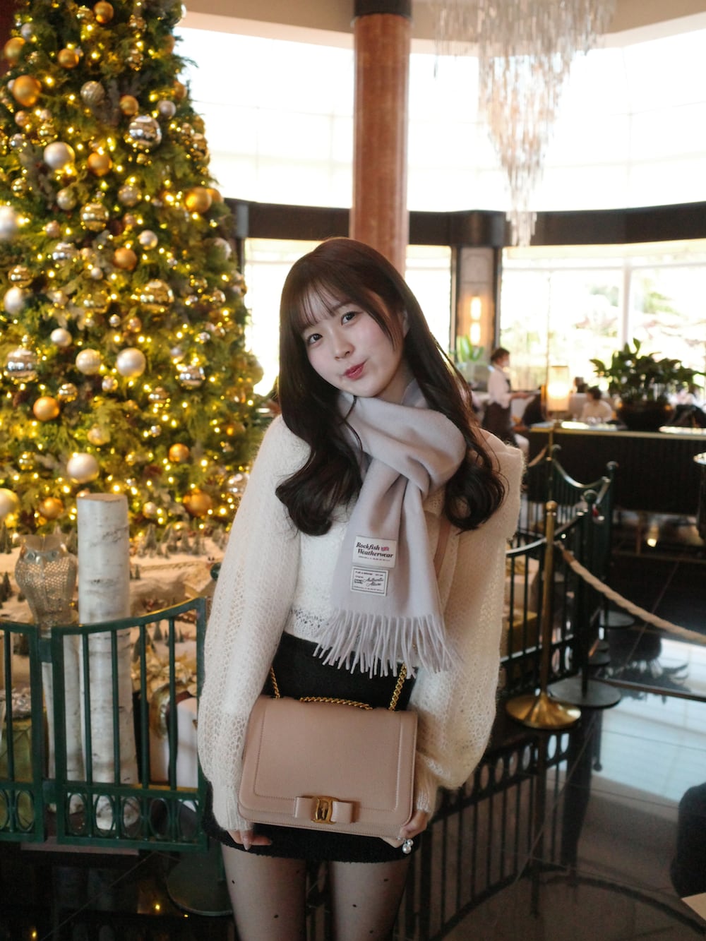 ホワイト系のニット/セーター、ベージュ系のショルダーバッグ、ブラック系のスカートを着用したレディースの冬コーディネートの4枚目の写真