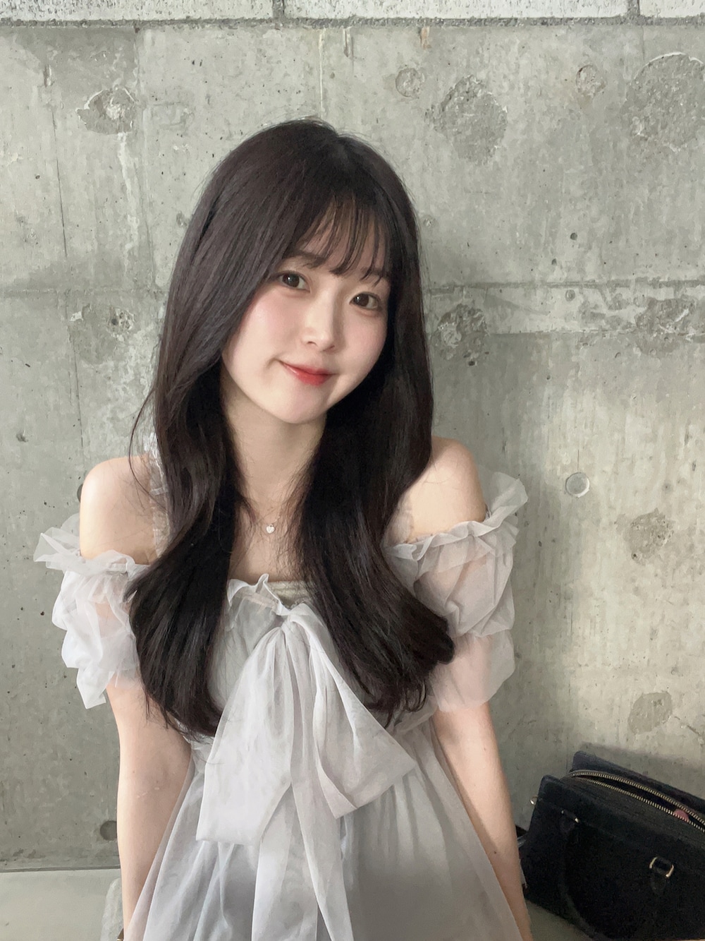 グレー系のシャツ/ブラウス、ブラック系のバッグ、ホワイト系のスカートを着用したレディースの夏コーディネートの4枚目の写真