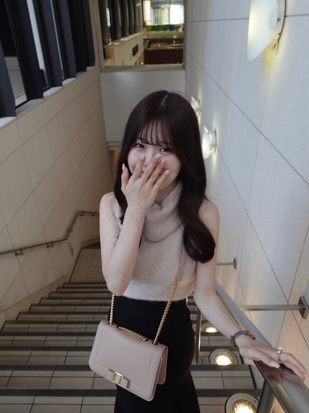 ピンク系のバッグ、ピンク系のニット/セーター、ブラック系のスカートを着用したレディースの秋コーディネートの4枚目の写真