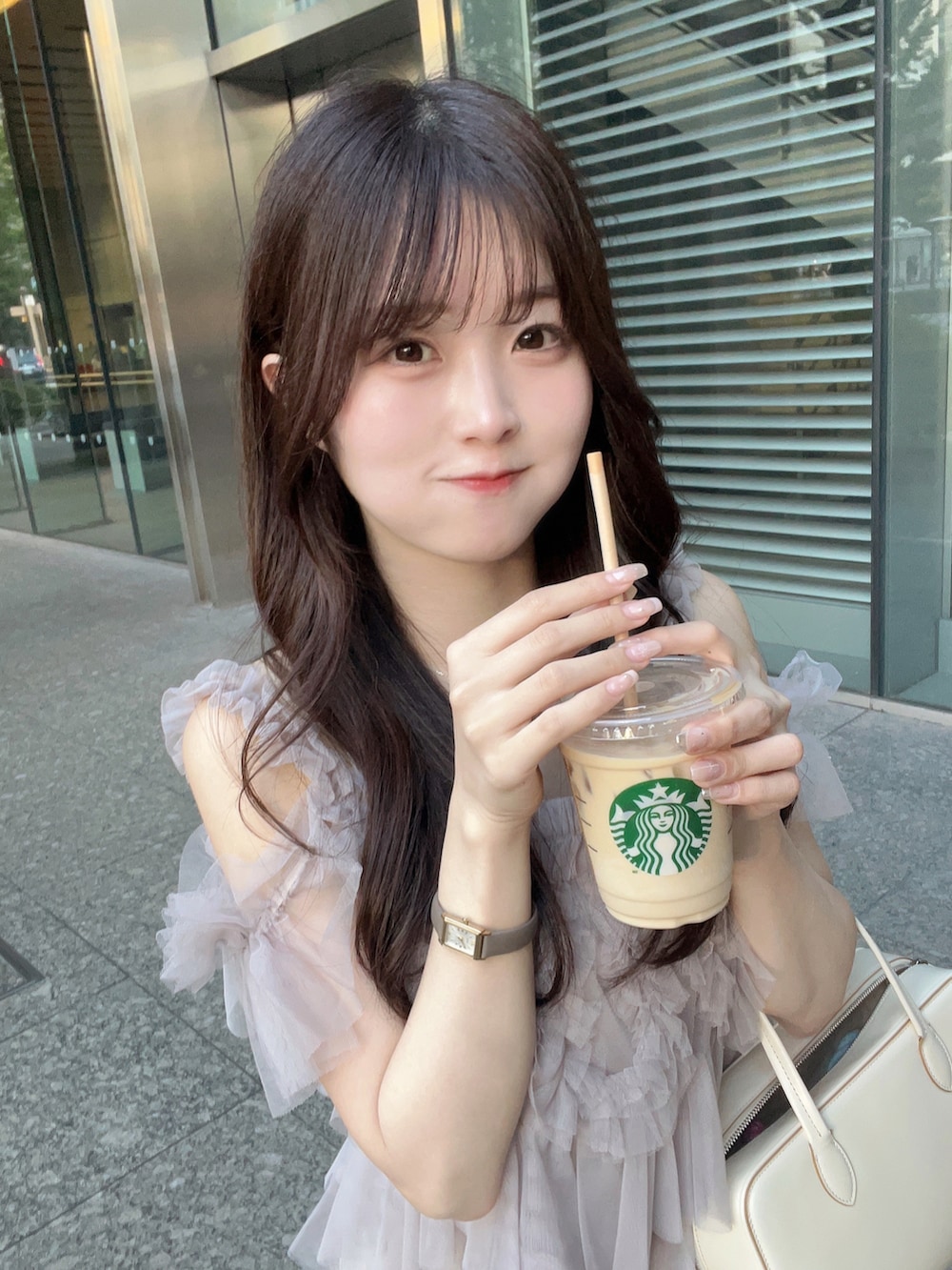 ホワイト系のバッグ、ピンク系のトップス、ホワイト系のスカートを着用したレディースの夏コーディネートの4枚目の写真