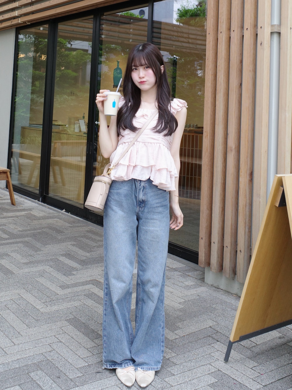 ホワイト系のサンダル、ピンク系のトップス、ブルー系のデニムパンツを着用したレディースの夏コーディネートの2枚目の写真