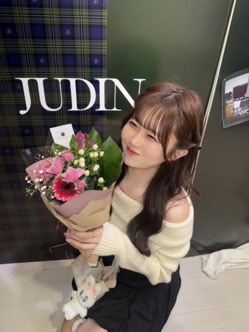 ホワイト系のニット/セーター、ホワイト系のスカート、ベージュ系のショルダーバッグを着用したレディースの秋コーディネートの2枚目の写真