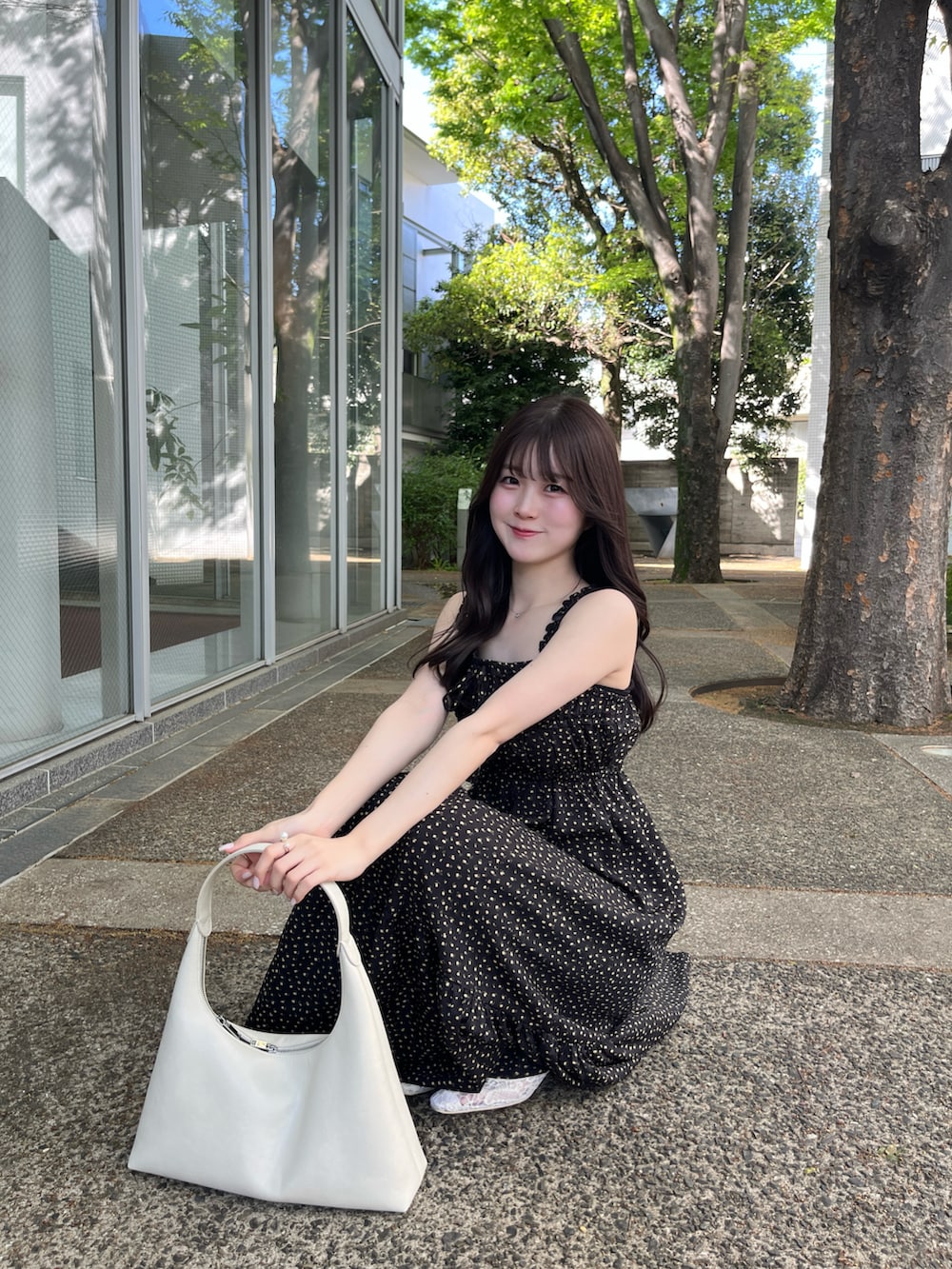 ブラック系のワンピース/ドレス、ホワイト系のシューズを着用したレディースの春コーディネートの3枚目の写真