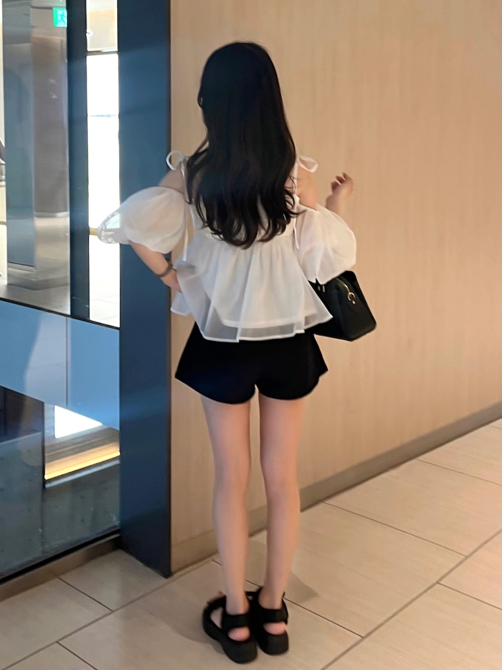 ブラック系のパンツ、ホワイト系のシャツ/ブラウス、ブラック系のバッグを着用したレディースの夏コーディネートの2枚目の写真