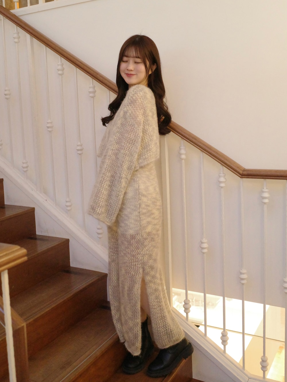 グレー系のワンピース、グレー系のニット/セーター、ベージュ系のショルダーバッグを着用したレディースの冬コーディネートの2枚目の写真