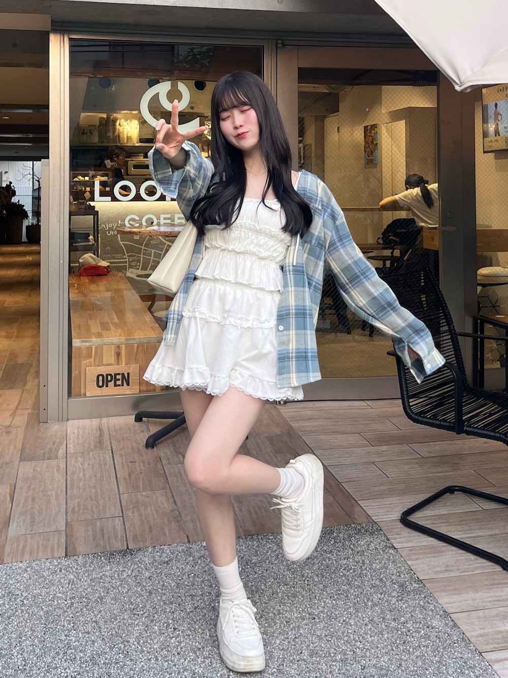 ホワイト系のスニーカー、ブルー系のシャツ/ブラウス、ホワイト系のスカートを着用したレディースの夏コーディネートの2枚目の写真