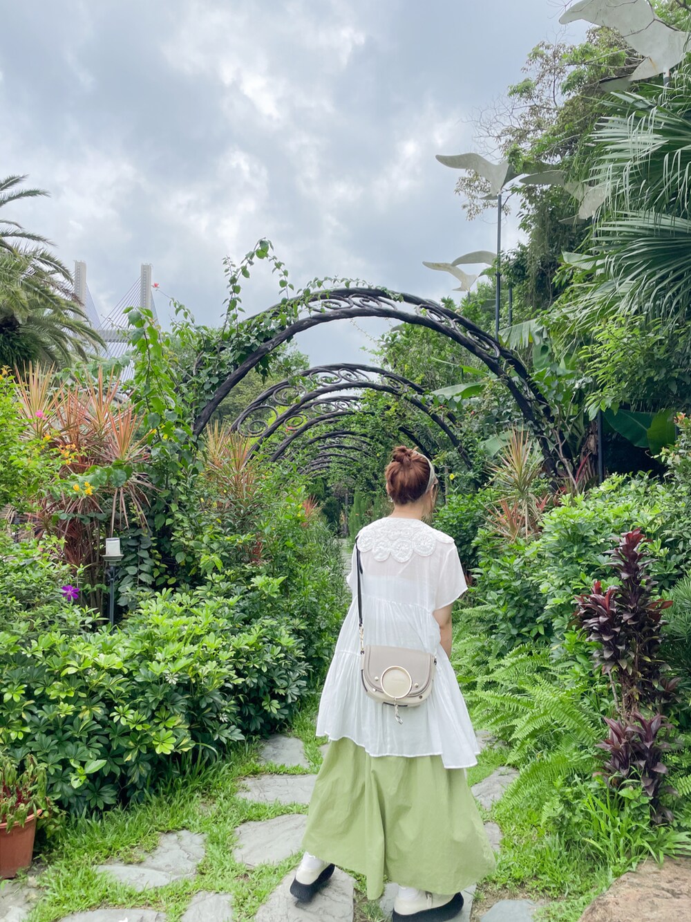 ホワイト系のシューズ、ベージュ系のショルダーバッグを着用したレディースの夏コーディネートの2枚目の写真