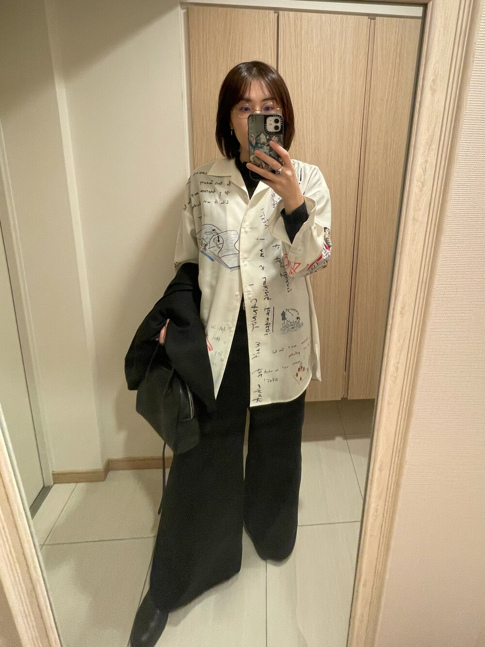 ホワイト系のシャツ/ブラウス、ブラック系のテーラードジャケット、ブラック系のハンドバッグを着用したレディースの秋コーディネートの2枚目の写真