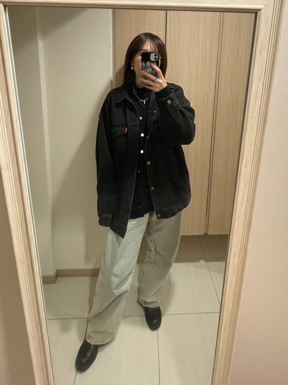 ブラック系のカーディガン/ボレロ、ブラック系のデニムジャケット、ブルー系のデニムパンツを着用したレディースの秋コーディネートの2枚目の写真