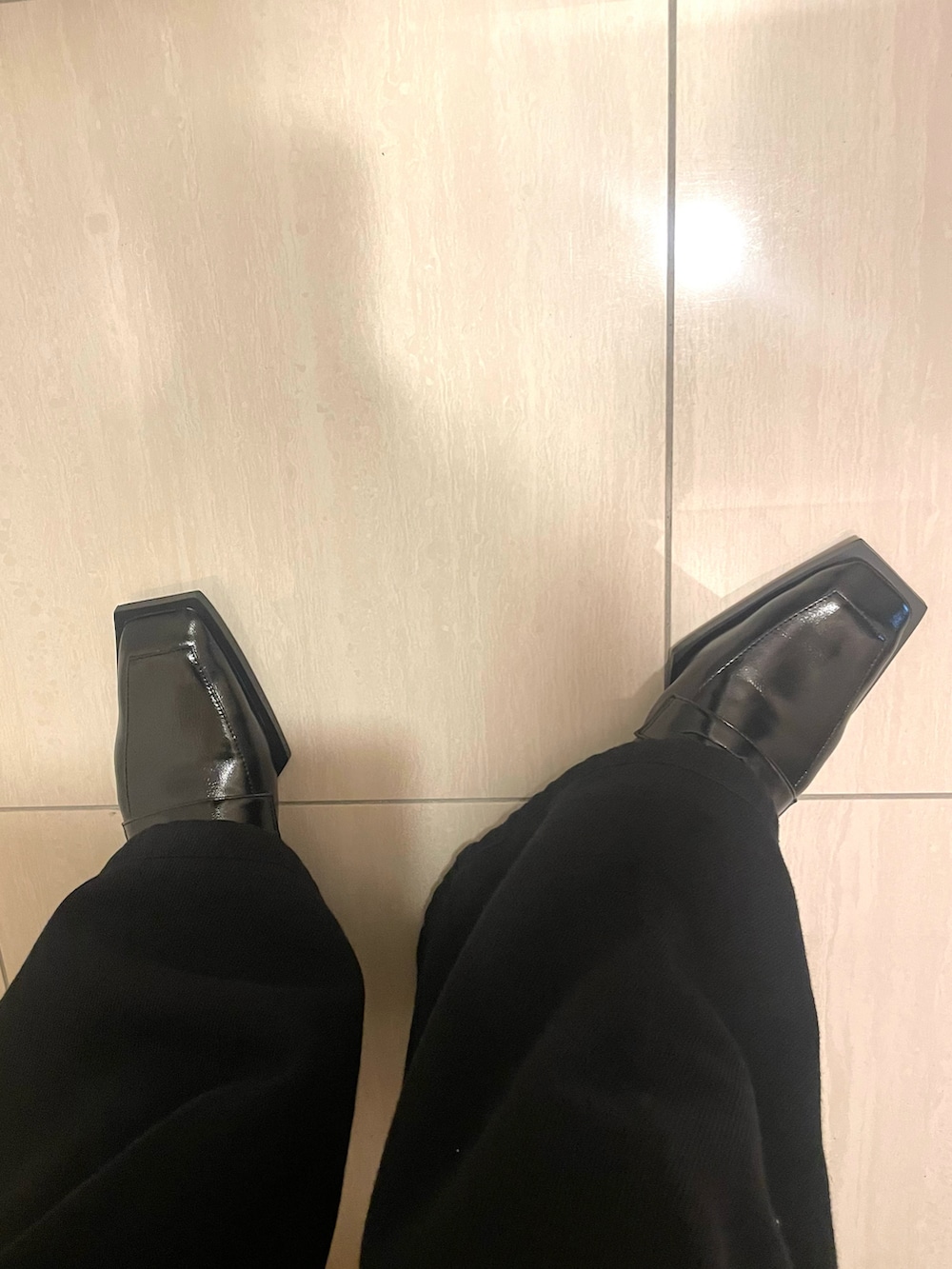 ブラック系のトレンチコート、イエロー系のハンドバッグを着用したレディースの春コーディネートの3枚目の写真