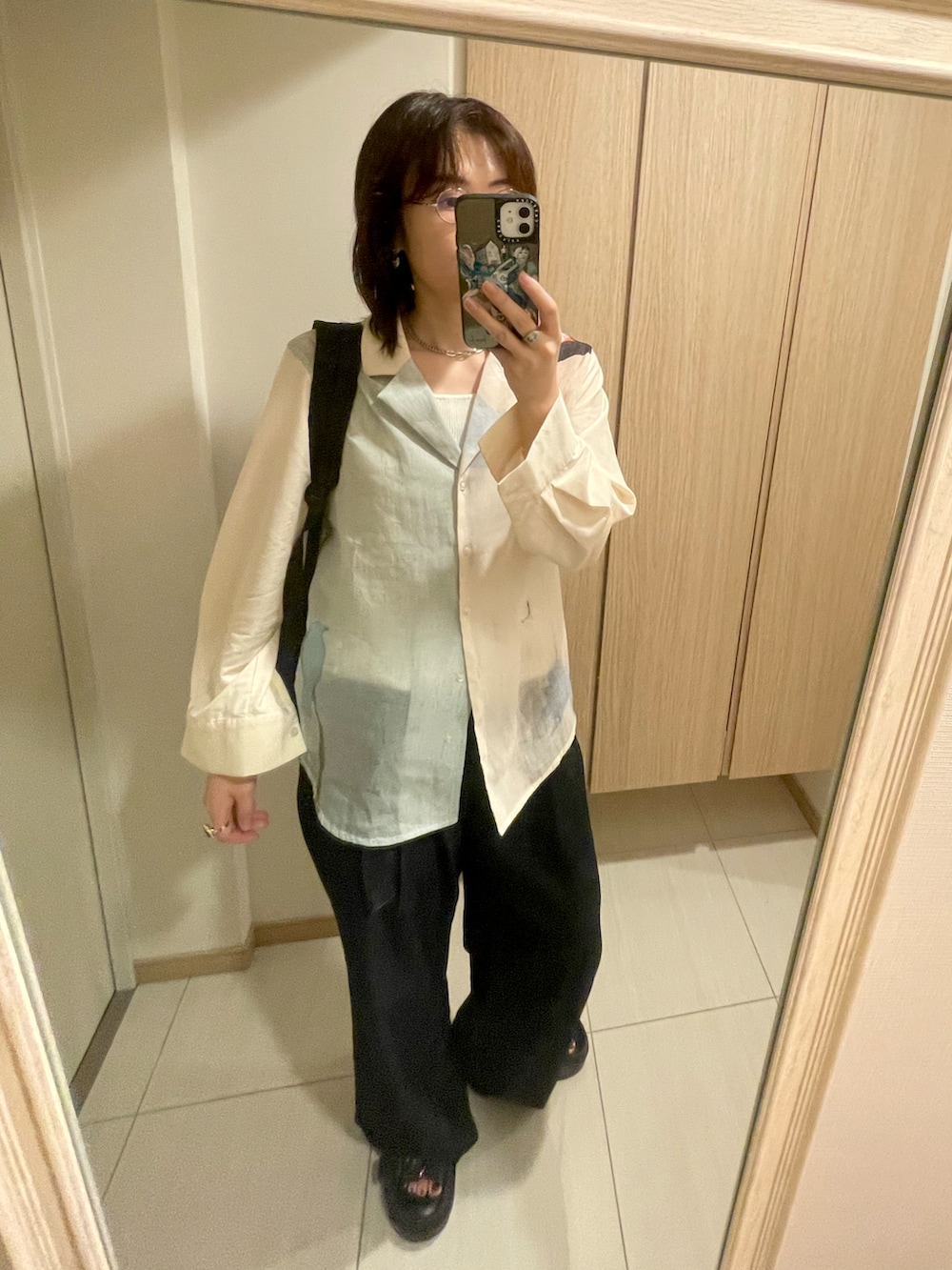 ベージュ系のシャツ/ブラウス、ブルー系のデニムパンツ、シルバー系のピアス（両耳用）を着用したレディースの秋コーディネートの3枚目の写真