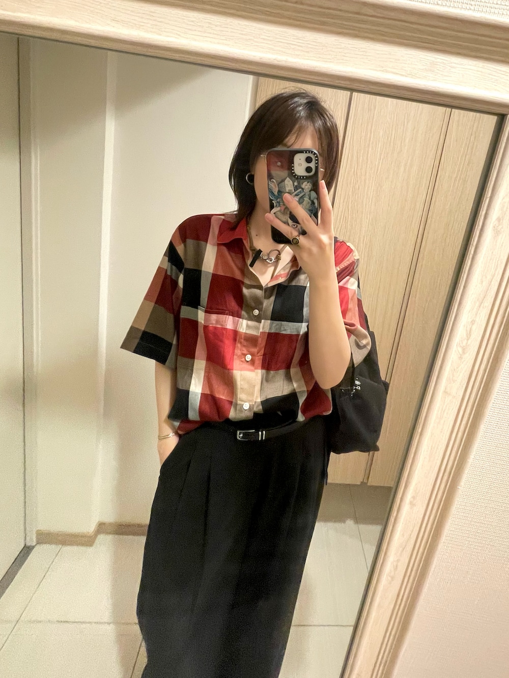 レッド系のシャツ/ブラウス、ブラック系のスラックス、ベージュ系のネックレスを着用したレディースの秋コーディネートの2枚目の写真