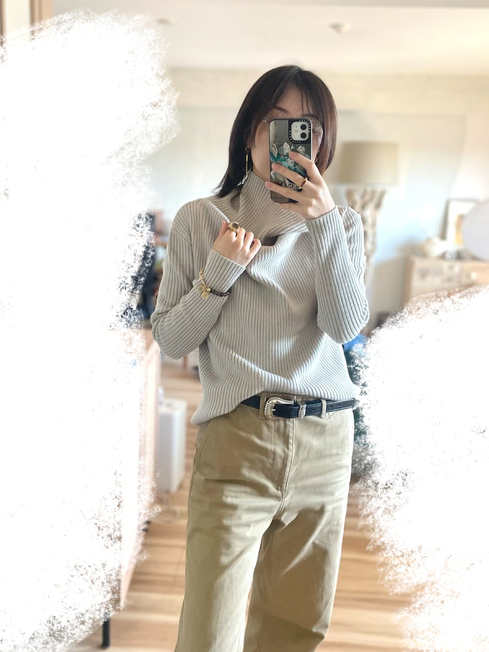 ベージュ系のトップス、ブラック系のベルト、ゴールド系のリングを着用したレディースの春コーディネートの2枚目の写真