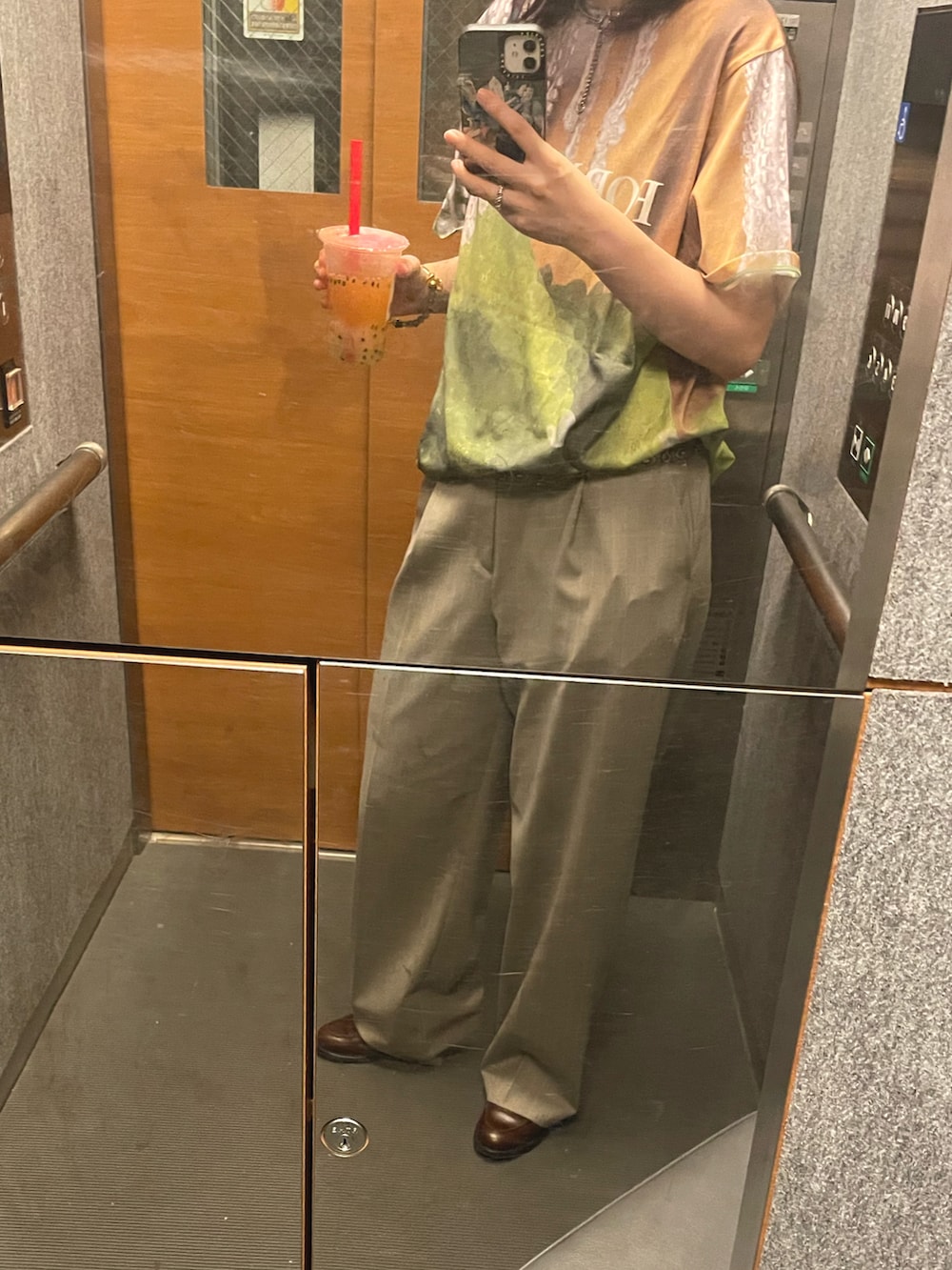グリーン系のTシャツ/カットソー、グレー系のパンツ、シルバー系のベルトを着用したレディースの夏コーディネートの2枚目の写真