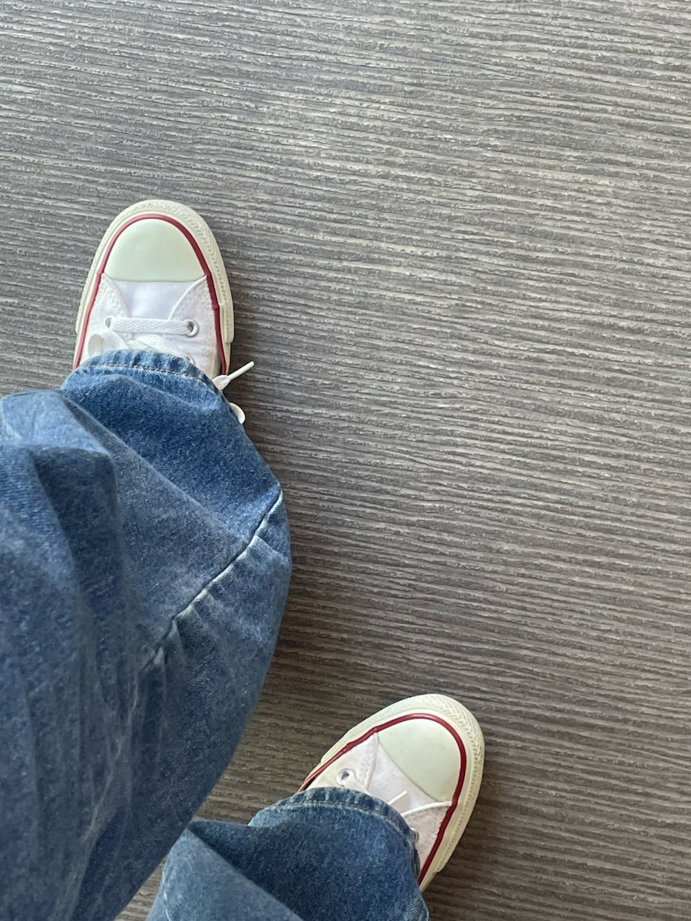 ブルー系のデニムパンツ、ホワイト系のトップス、レッド系のカーディガン/ボレロを着用したレディースの春コーディネートの3枚目の写真