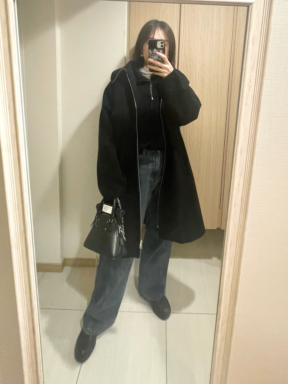 ブルー系のデニムパンツ、ブラック系のショルダーバッグ、ブルー系のニット/セーターを着用したレディースの冬コーディネートの2枚目の写真