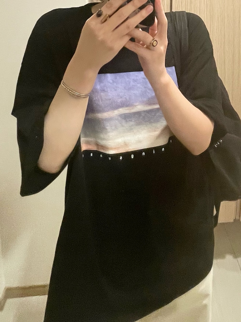 ブラック系のTシャツ/カットソー、ホワイト系のパンツ、ブラック系のスニーカーを着用したレディースの秋コーディネートの2枚目の写真